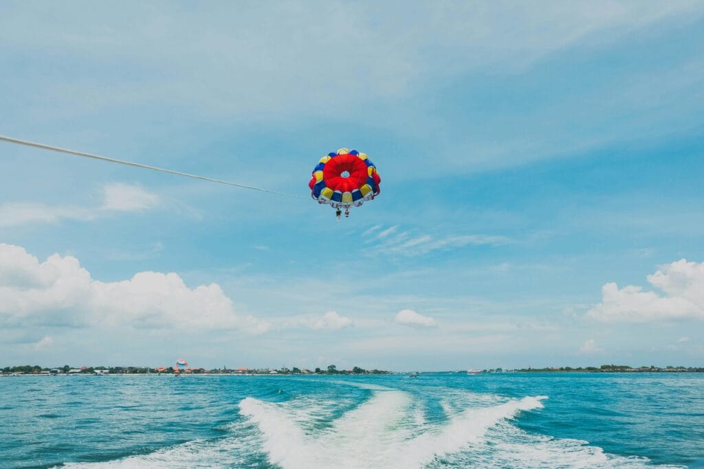 Parasailing adventure at Tanjung Benoa Bali with tropical coastline views
