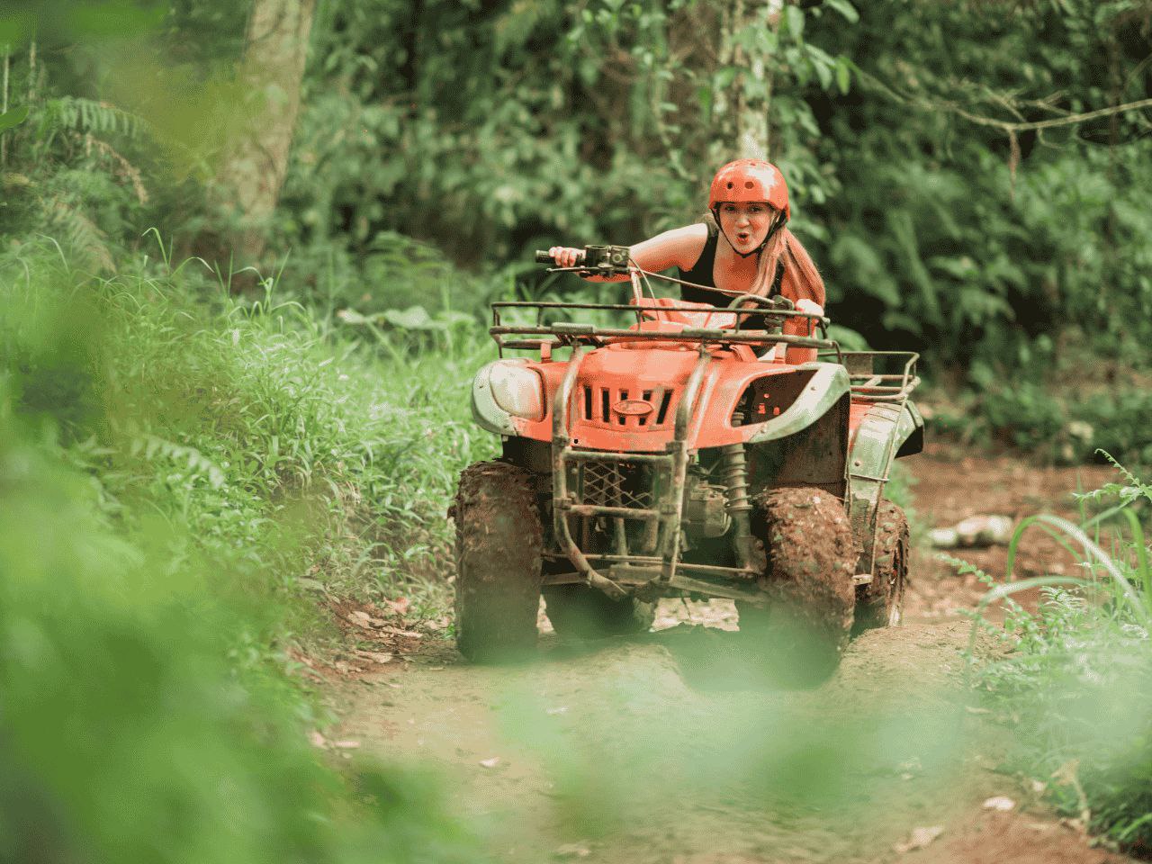 Tourists enjoying Ubud ATV ride across river and rice fields