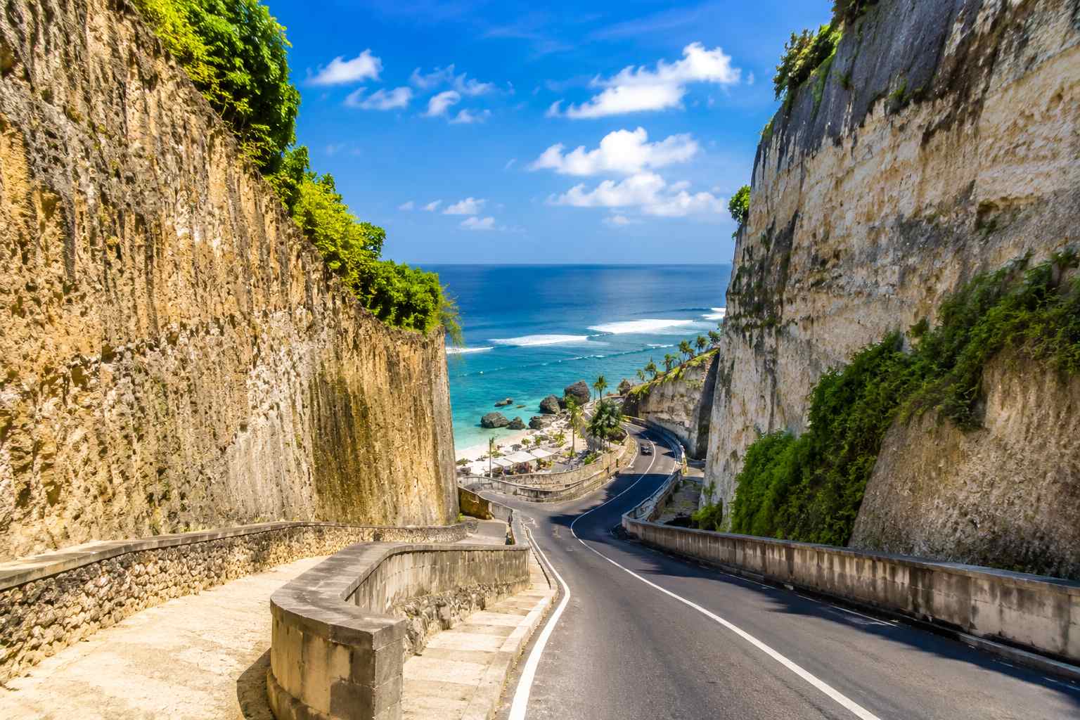 Melasti Beach Bali sunset view featuring white sand beach, calm ocean water, and limestone cliffs