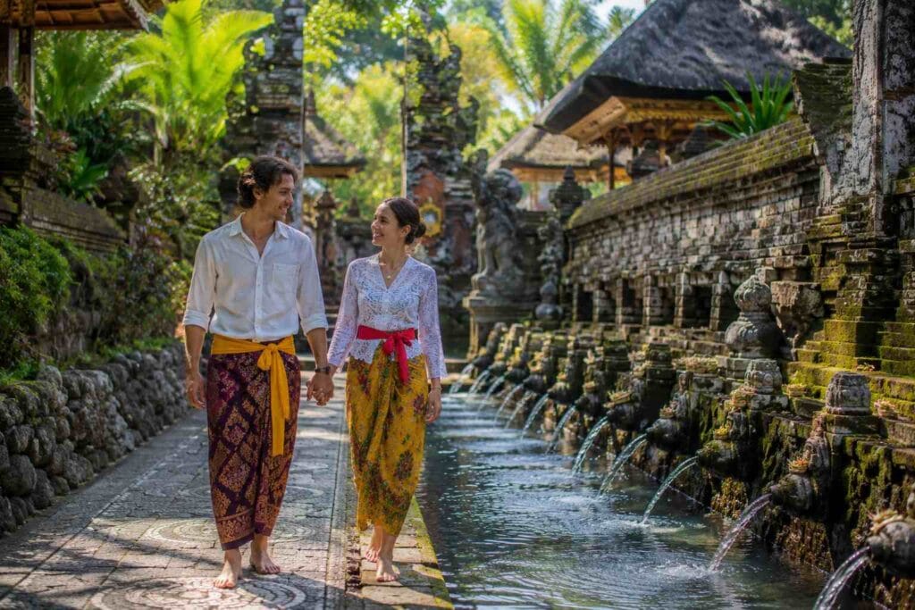 Bali Temple Dress Code at a traditional Balinese temple entrance with tourists wearing sarongs