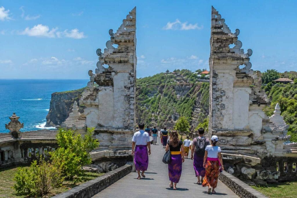 Bali Temple Dress Code at a traditional Balinese temple entrance with tourists wearing sarongs