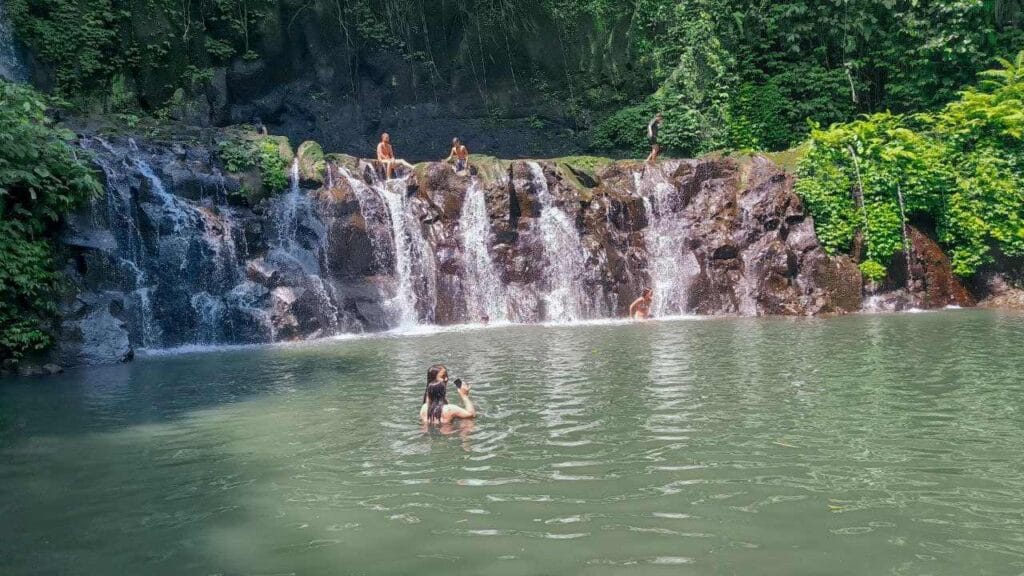 Taman Sari Waterfall Bali flowing through a natural rocky landscape